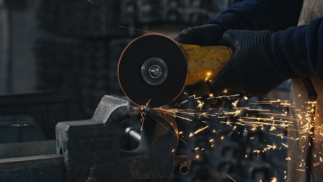 A person working with a grinder on a piece of metal