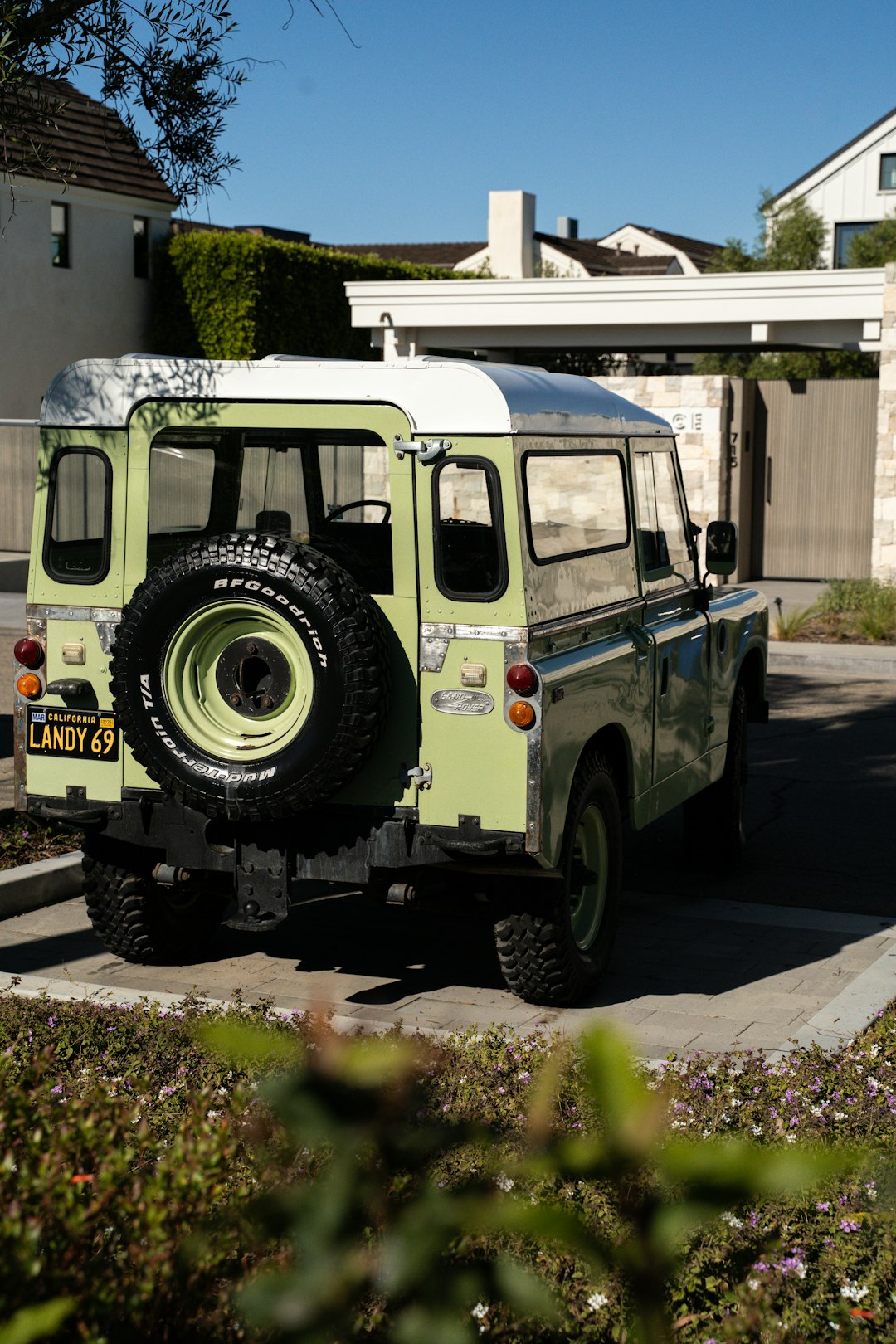 A vintage green land rover defender parked outdoors.