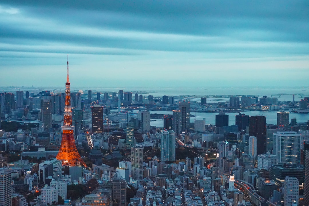tokyo tower illuminated at dusk with city skyline