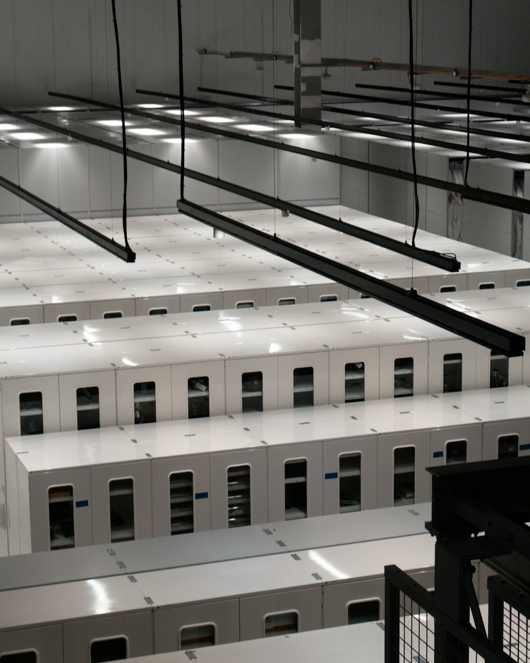 Modern data center with rows of white server cabinets.