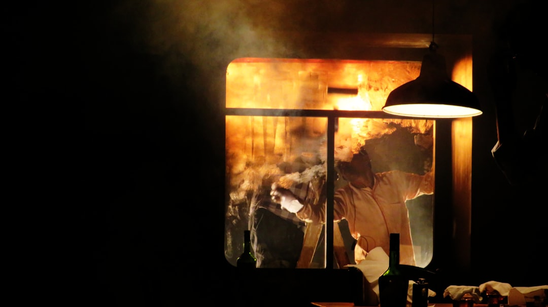 a person standing in front of a window with smoke coming out of it