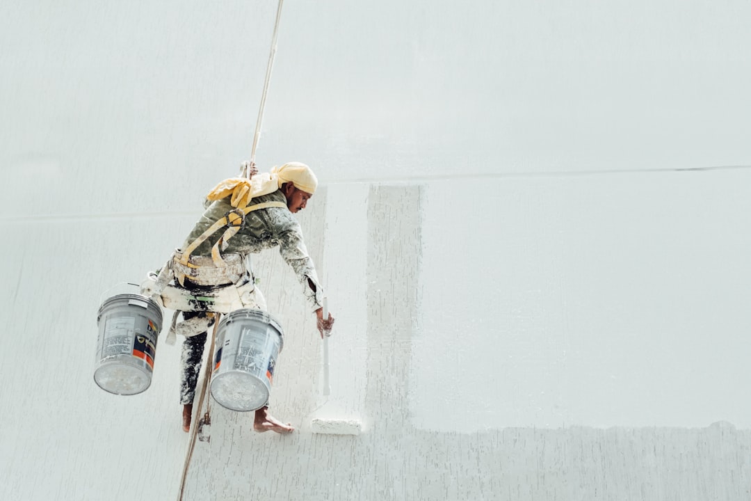 A painter is painting a white wall.