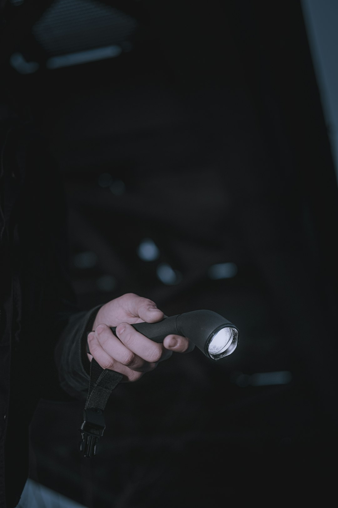 a person holding a flashlight in their hand