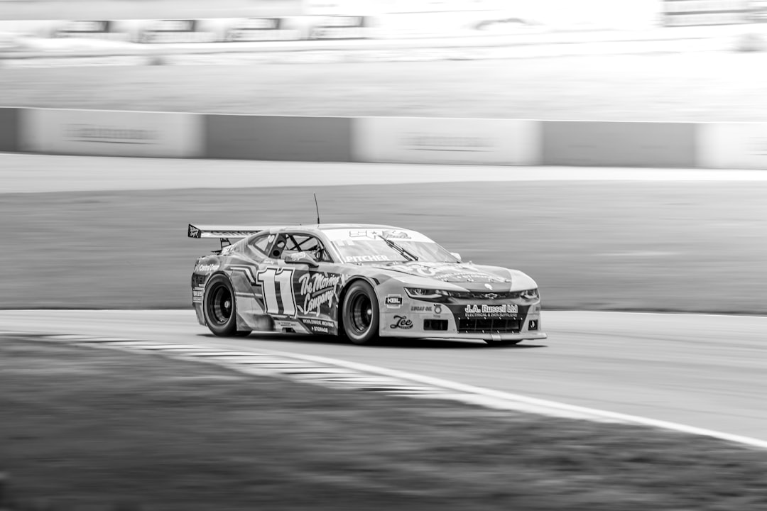 Black and white race car speeding on a blurred track.