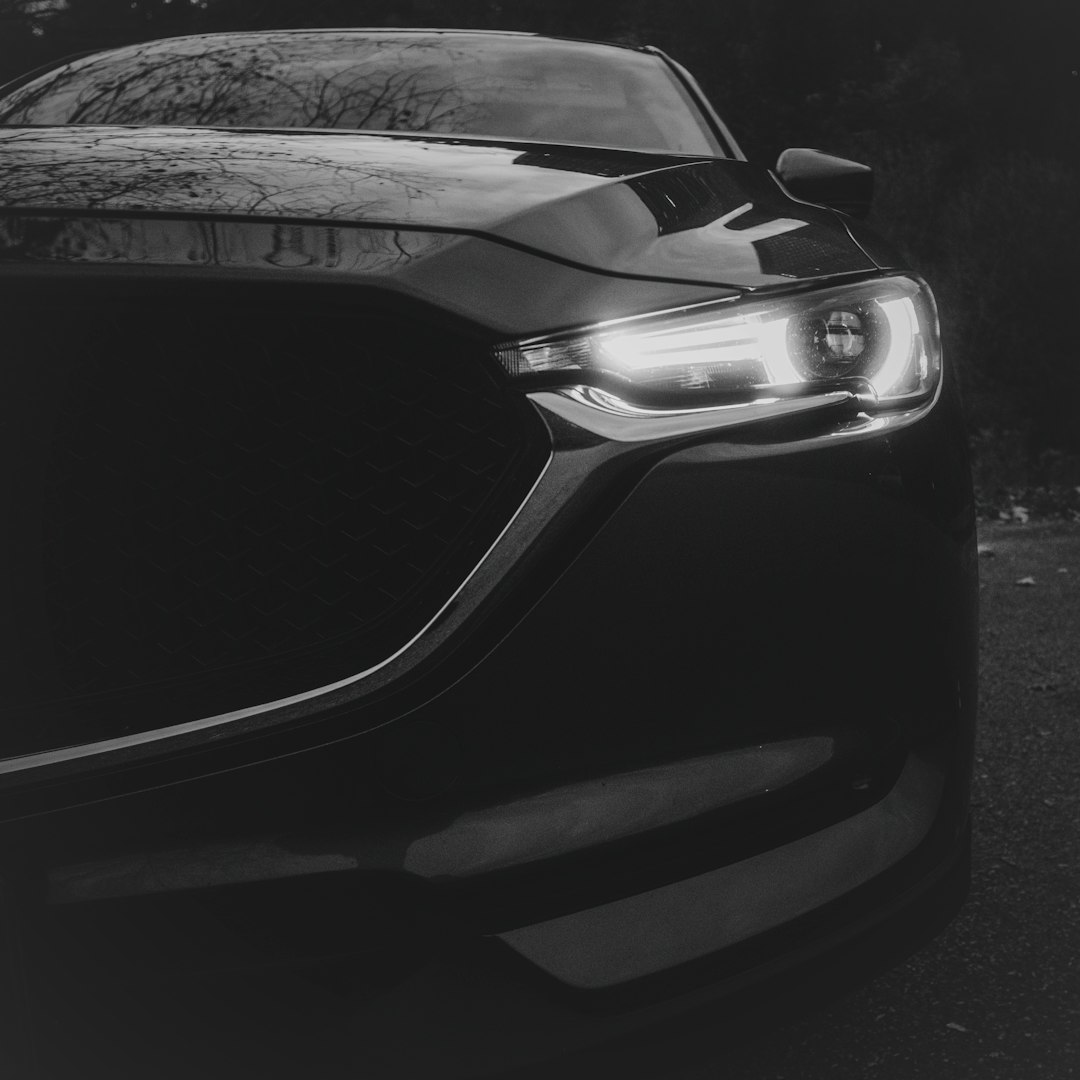 Close-up of a dark car with headlights on