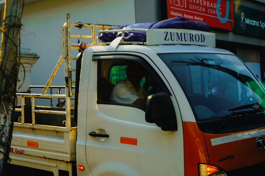 Man drives a white and orange truck with zumorod.