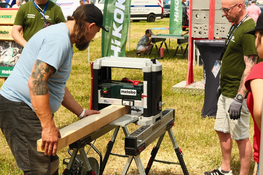 Man operating a woodworking planer with a wooden plank.
