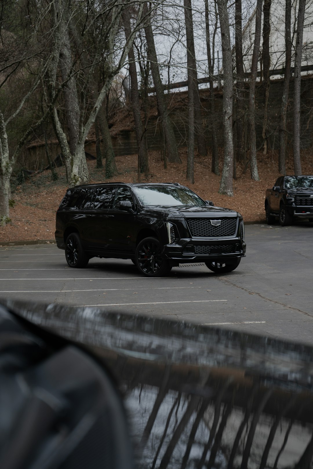 A black cadillac suv parked in a lot