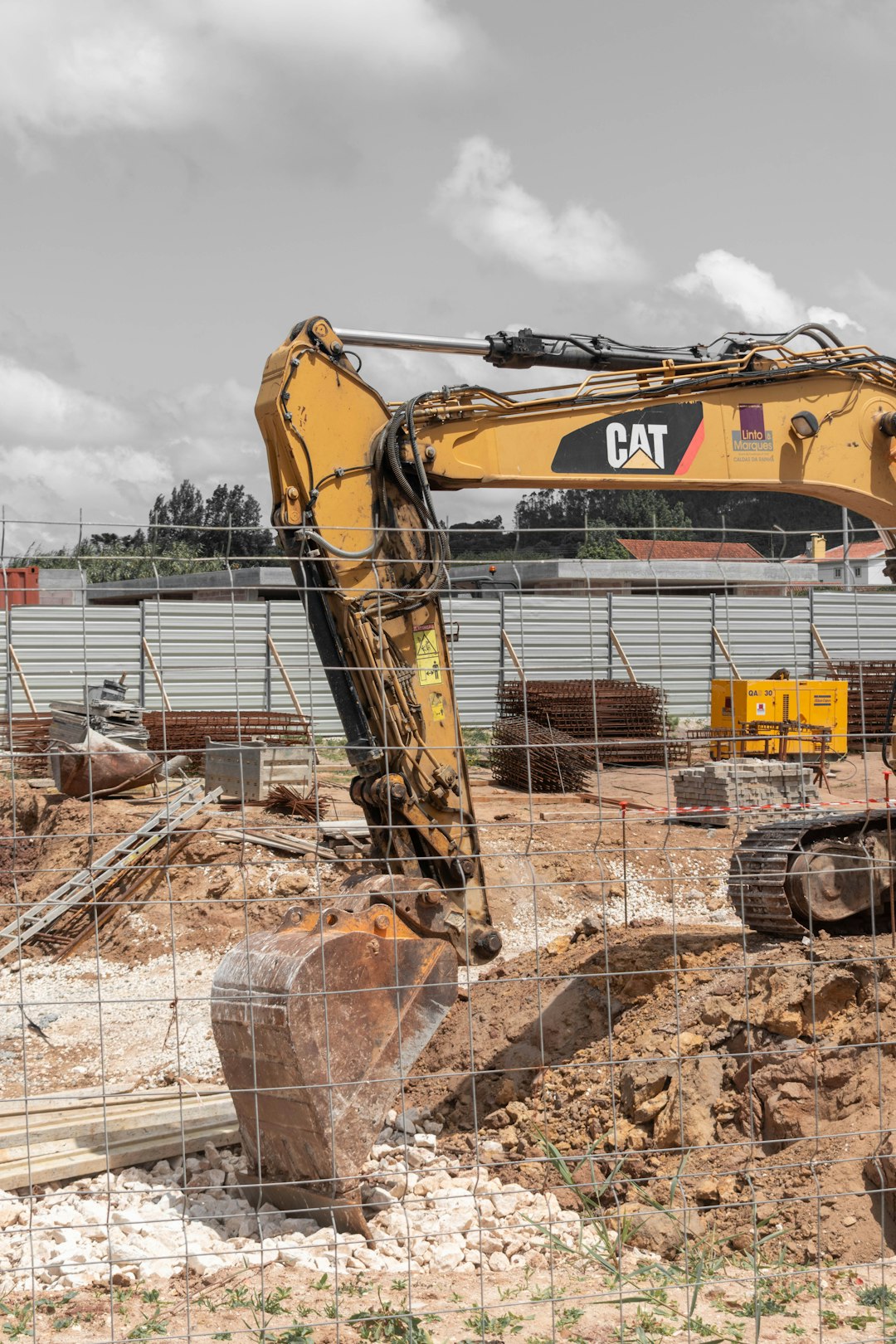 Yellow cat excavator digging on a construction site.