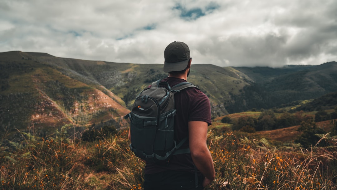 a man with a backpack standing on a hill