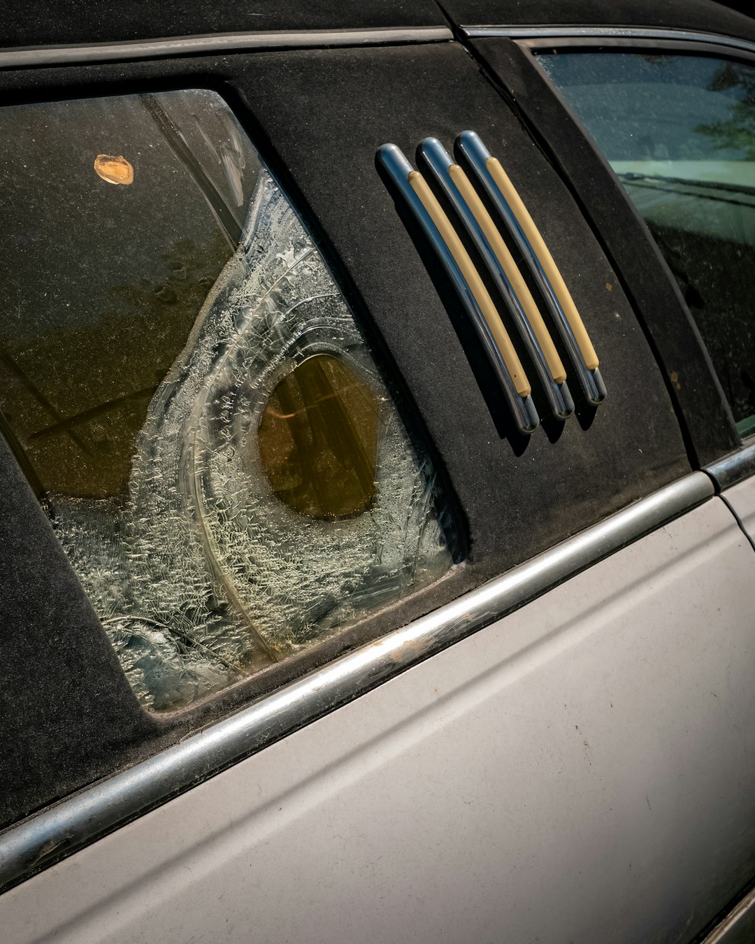 a broken windshield of a car with a broken window
