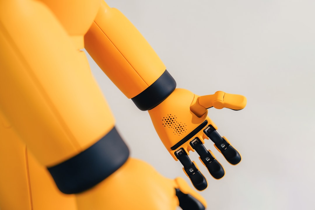 A yellow robotic arm with black joints and a mechanical hand