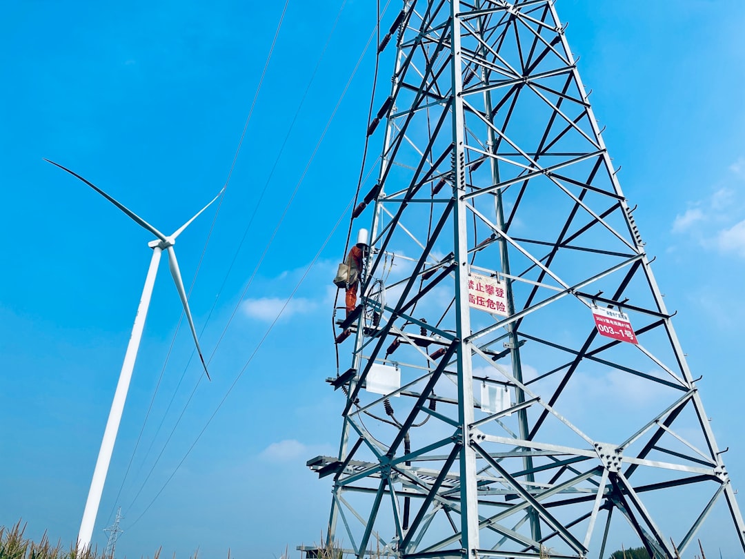 a man on a high voltage power line working on a wind turbine