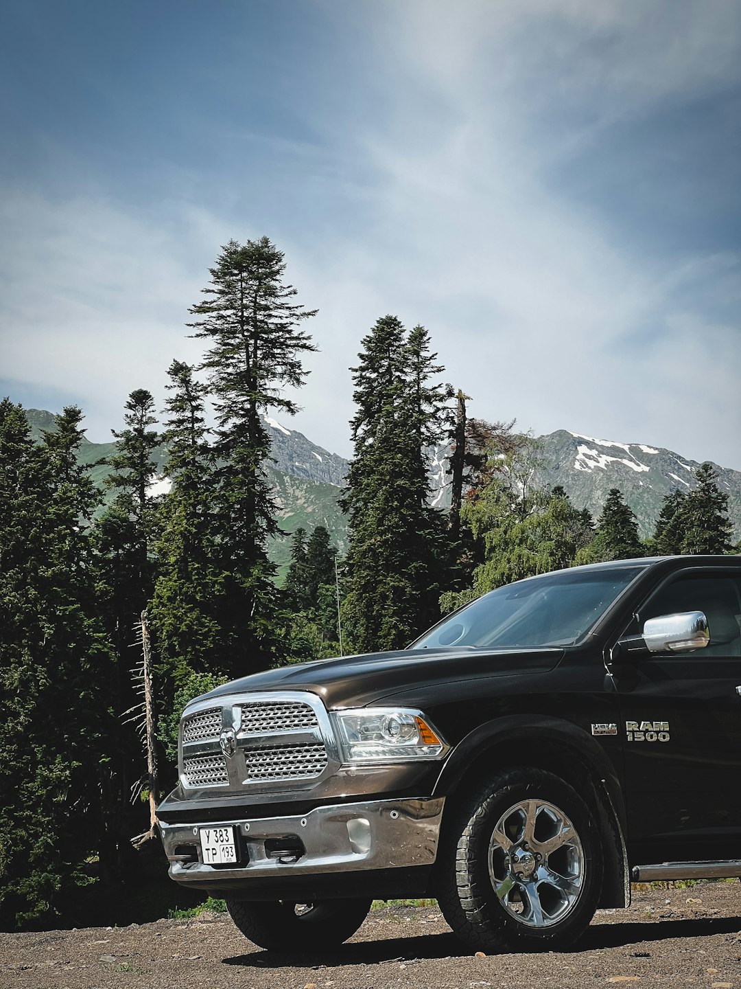 A dodge ram truck is parked near the mountains