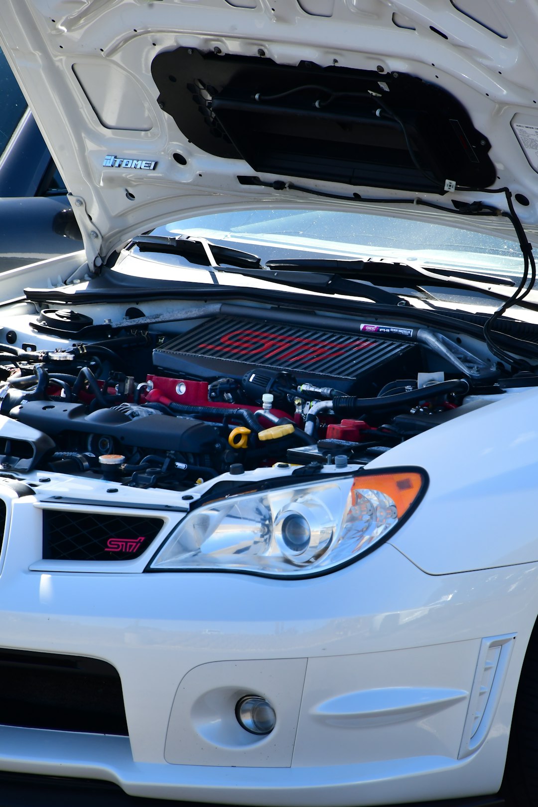 a white car with its hood open and the hood up