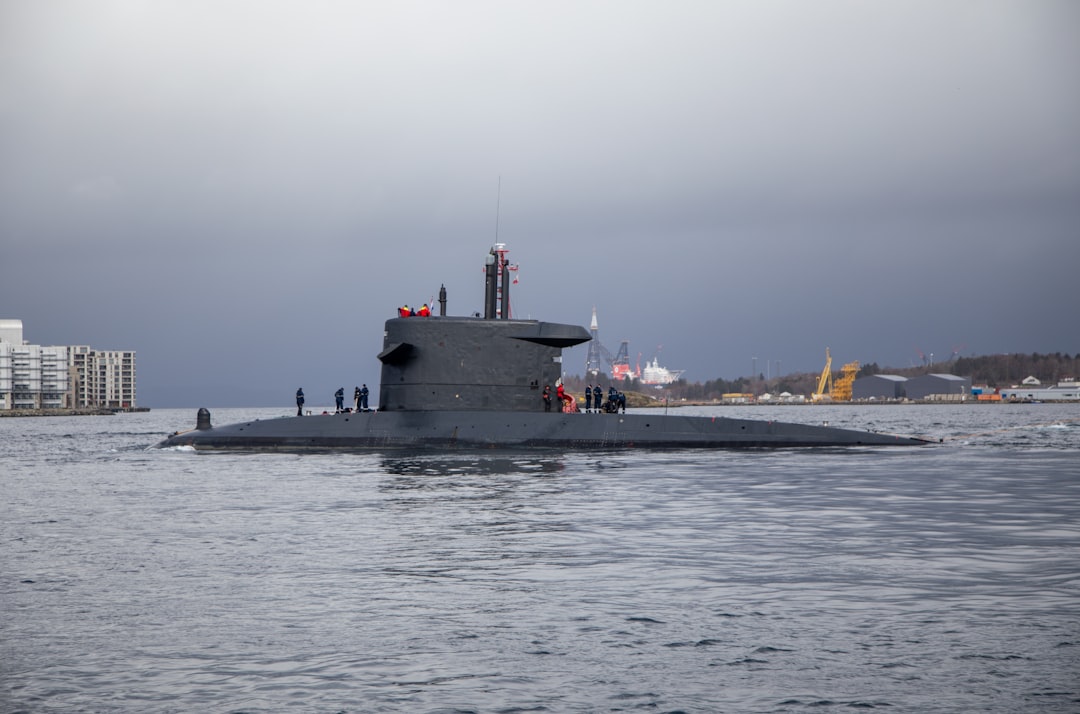 A submarine sails on the water with people on deck