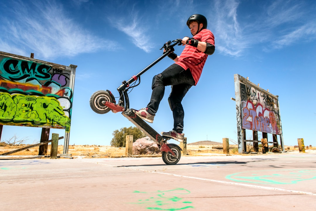 man in red and black jacket riding skateboard during daytime