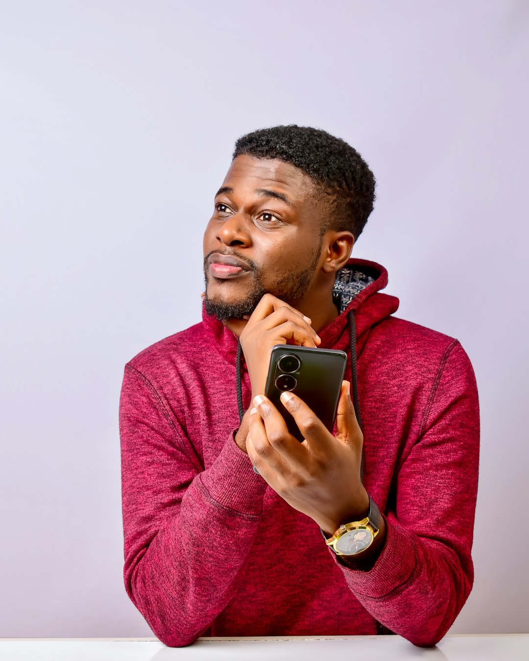 A man sitting at a table holding a cell phone