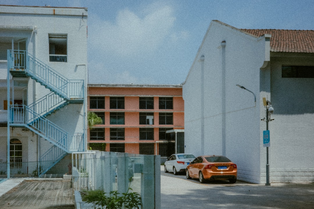 Orange building surrounded by white structures and parked cars