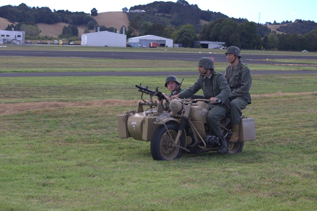 Soldiers ride a military motorcycle with machine gun.