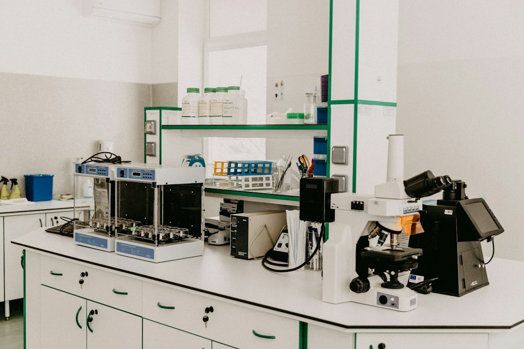 A laboratory workbench with a microscope and analytical equipment in a bright room
