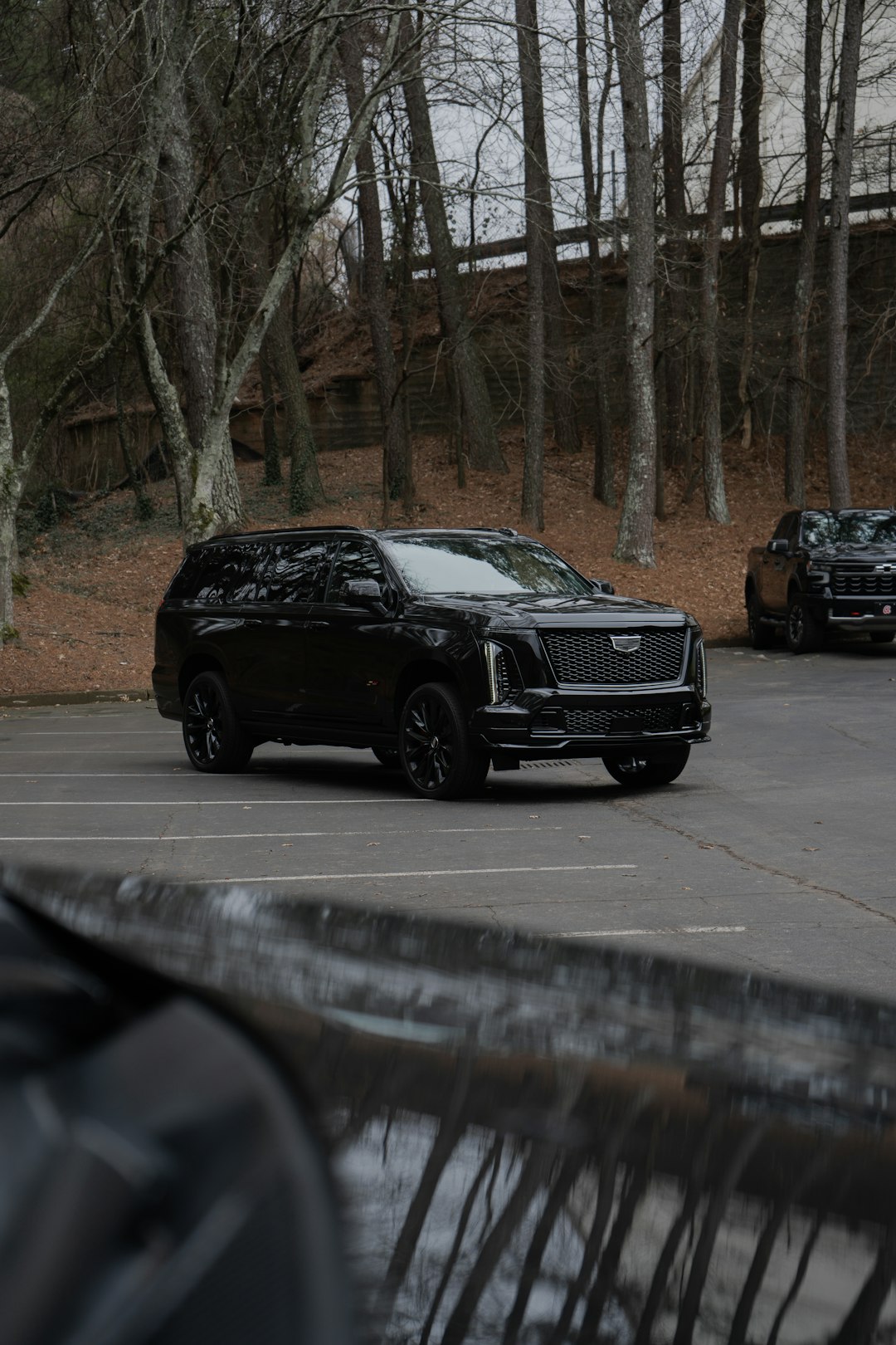 A black cadillac escalade parked in a lot