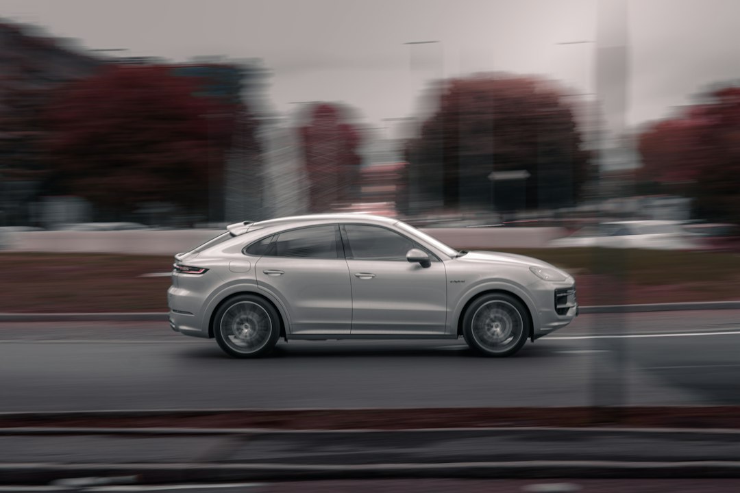 Silver luxury suv driving on a blurred city street