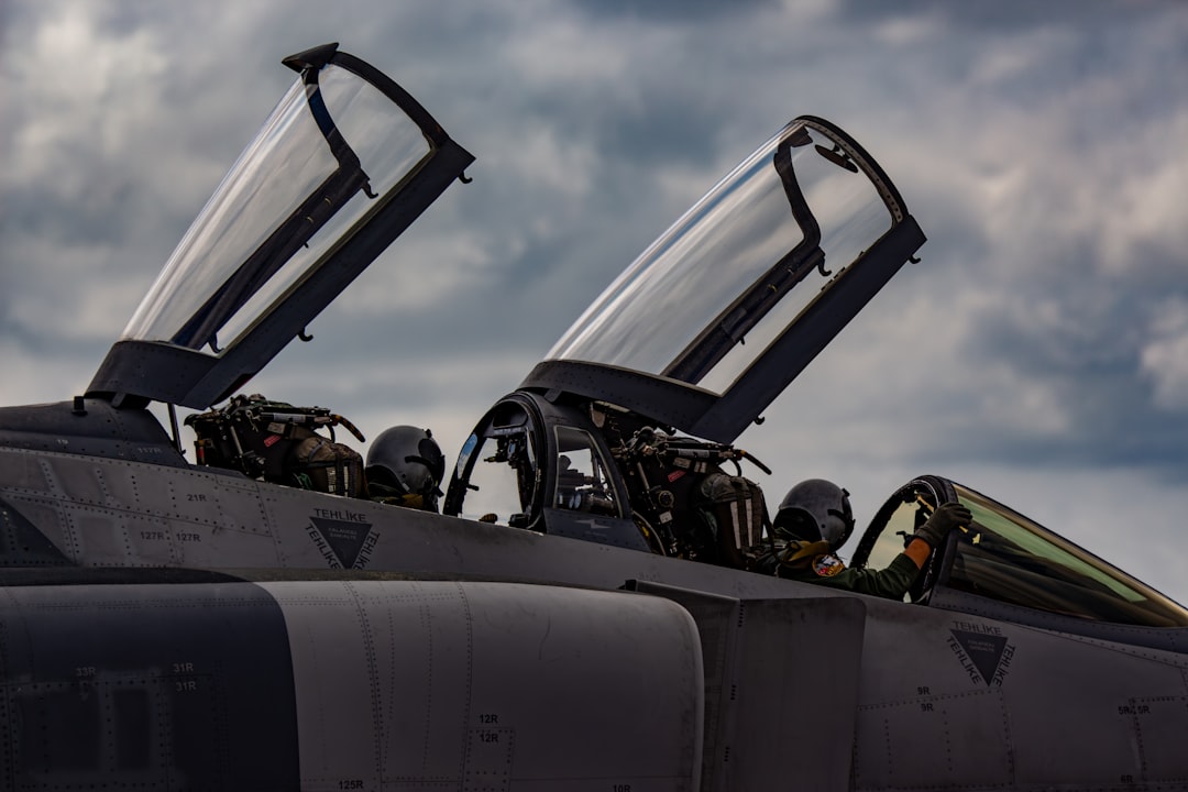 A fighter jet with its doors open on a cloudy day