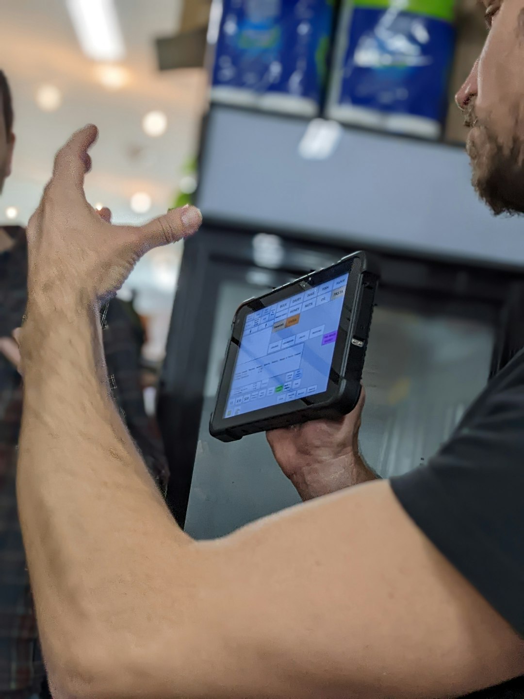 Man holding a rugged tablet and gesturing with his hand