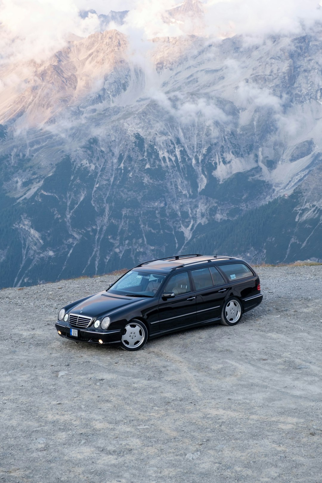 Black station wagon parked on a rocky mountain overlook