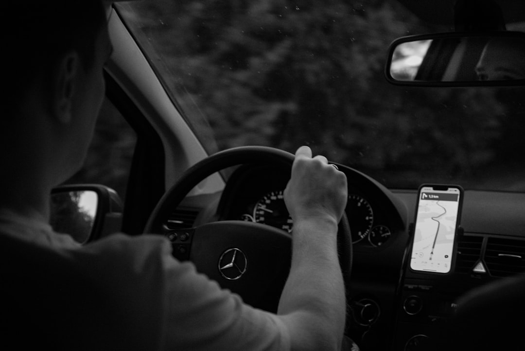 Person driving a car with gps navigation on phone