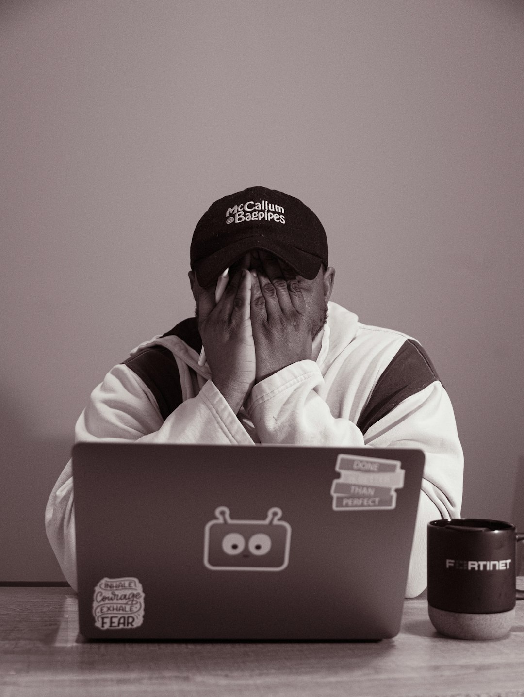 Person with hands over face at laptop
