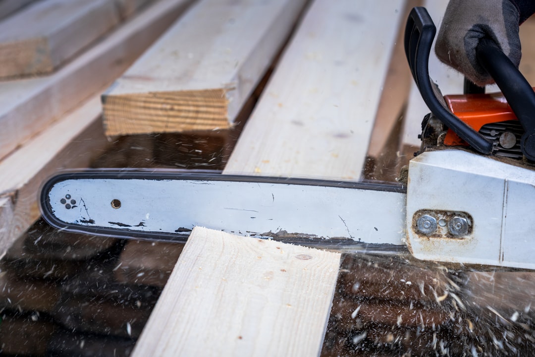 A chainsaw is cutting through a wooden plank